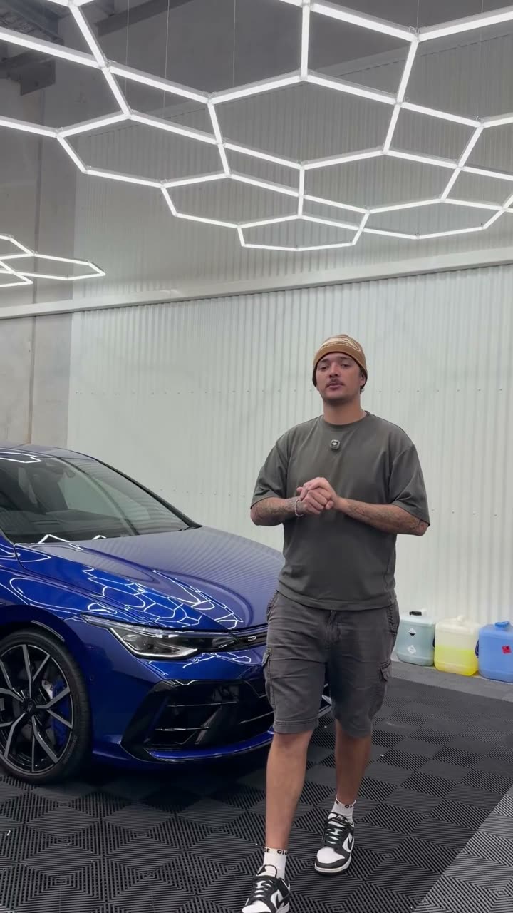 Anton with a blue VW Golf R in the shop